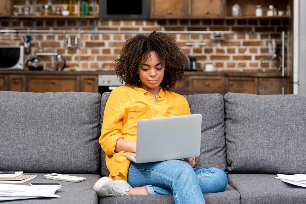 A person working on her laptop remotely, from home suggesting remote working is the new future?